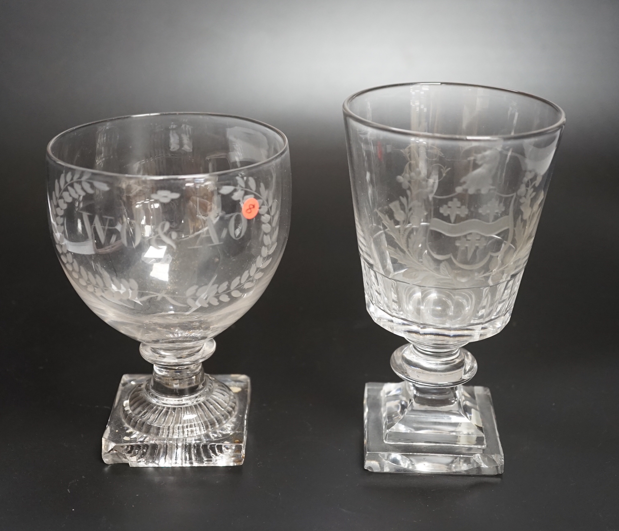 Two rummer style 18th century square-based goblets, both with etched designs, one a coat of arms, both stems with flattened knobs and cut glass square bases, one with ‘lemon squeezer’ pontil, highest 15.5cm